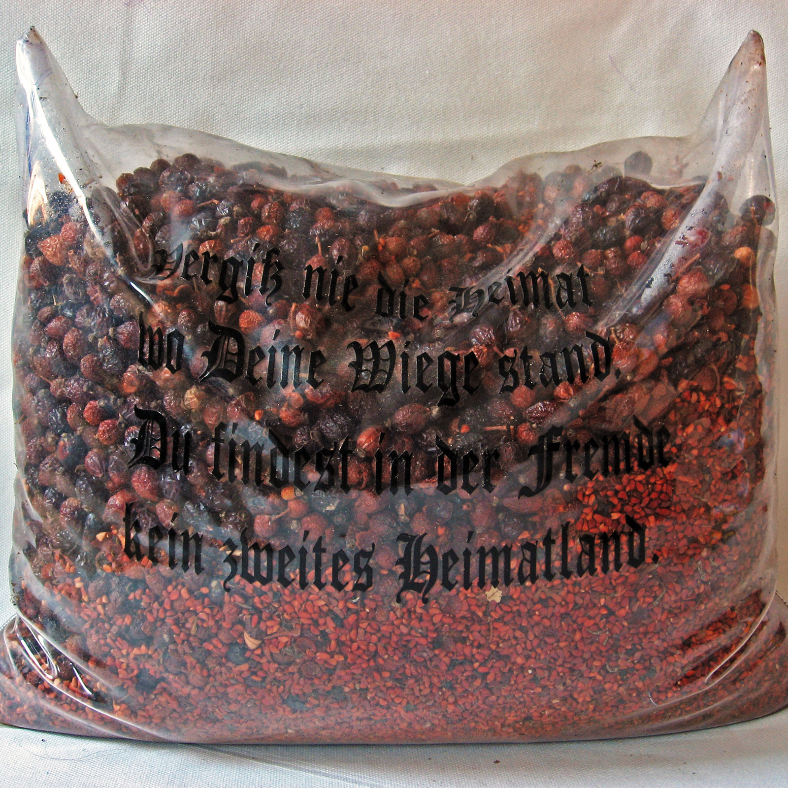 Zwölf Kissen aus Plastikfolie, bedruckt mit "Sinnsprüchen", Füllung aus Naturmaterialien